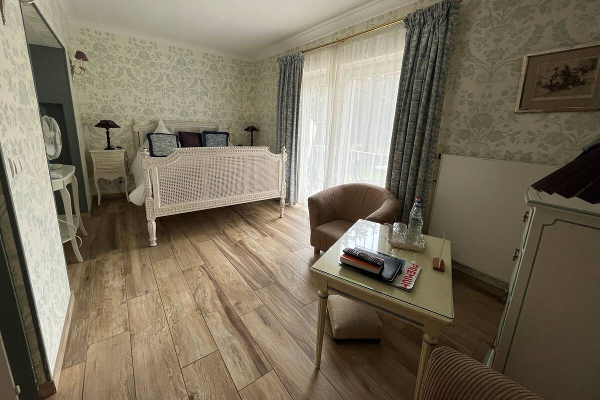 Ein Schlafzimmer mit Bett, Stuhl, Tisch und Kleiderschrank.