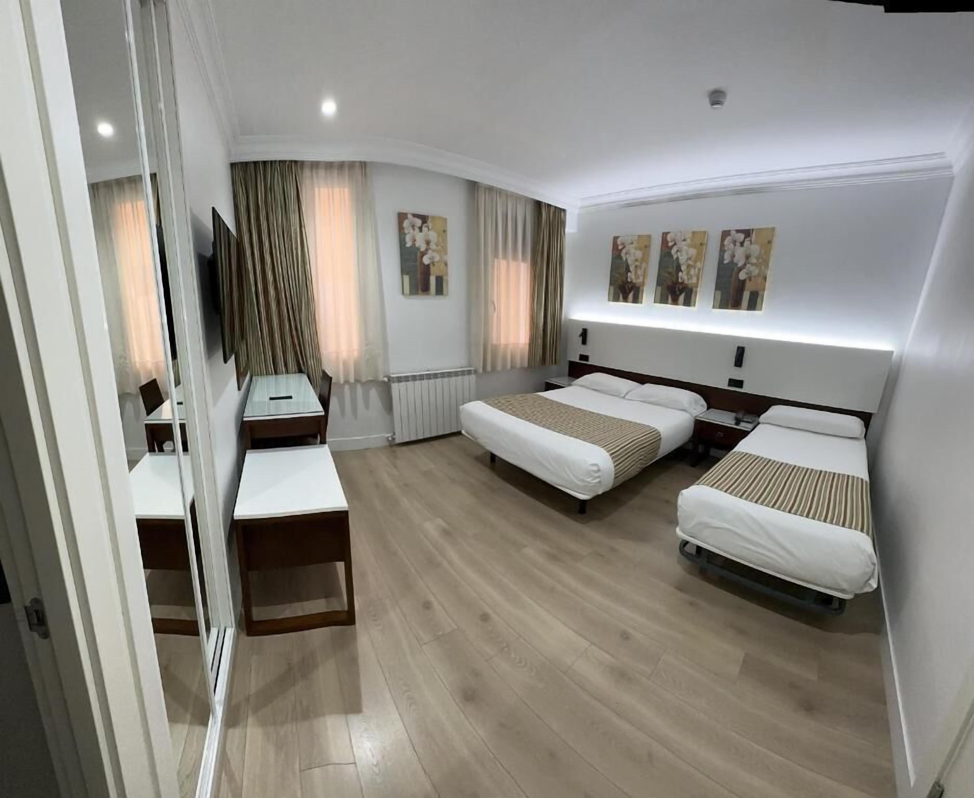 Ein Hotelzimmer mit gewölbter Wand, einem Bett, einem Schreibtisch und einem Spiegel.