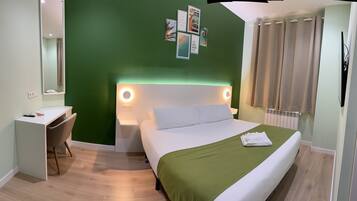 Una habitación de hotel con una cama, un escritorio y una silla.