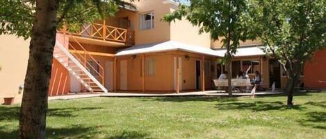 A building with a covered patio area, a staircase, and a small outdoor seating area.