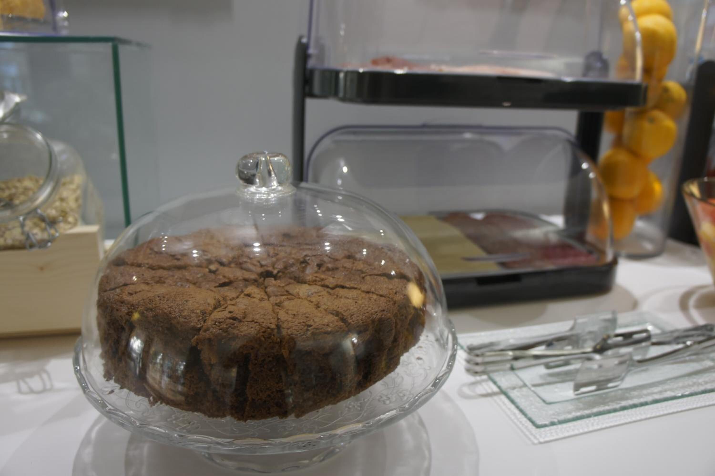 Un pastel con forma de cúpula de cristal sobre una base transparente.