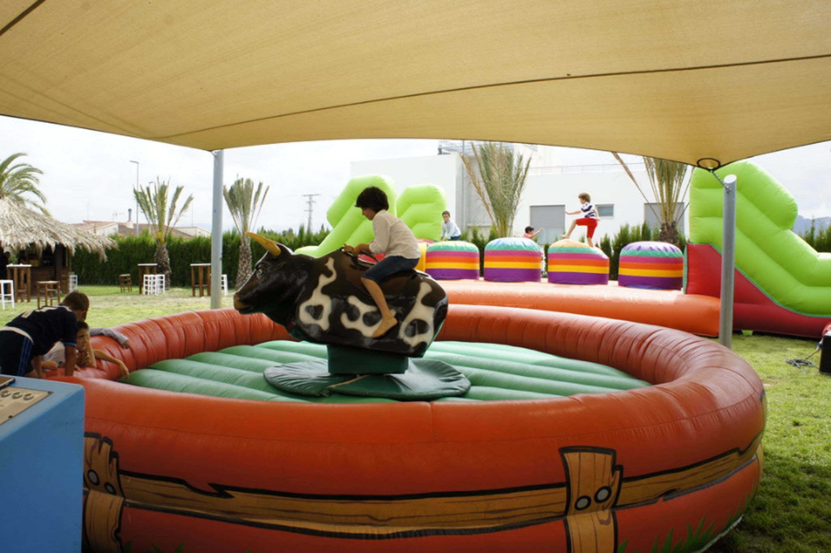 An inflatable play area with a child riding a cow-shaped ride.