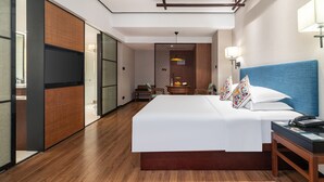 Une chambre d’hôtel moderne dotée d’un grand lit, d’un bureau et d’un dressing.