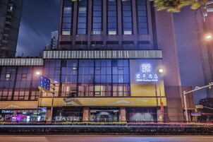 A hotel with a prominent sign, a visible entrance, and a street in front.