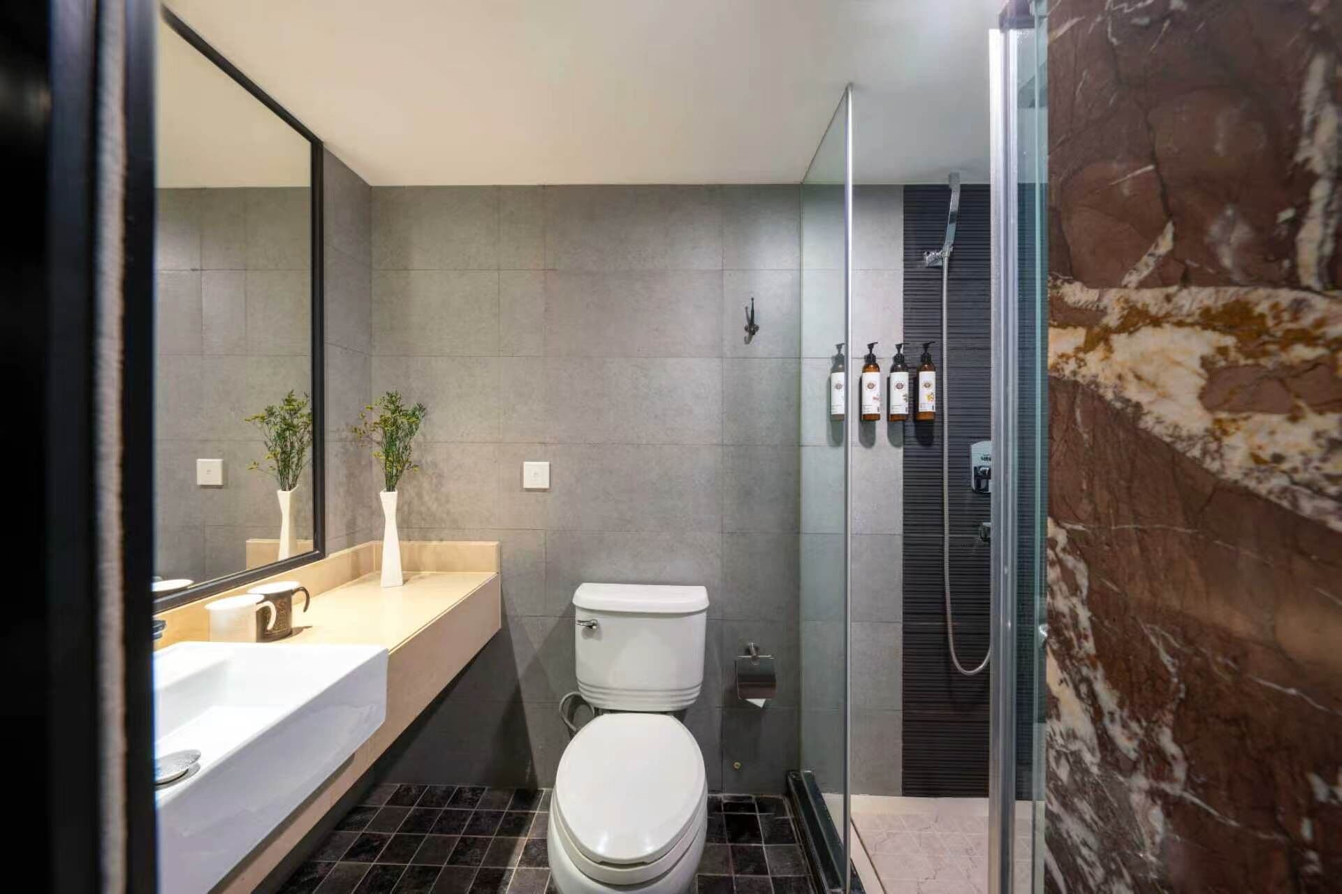 A modern bathroom with a toilet, sink, and shower.