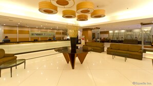 Un hall d’entrée moderne avec un comptoir d’accueil, des canapés et une table basse en verre.