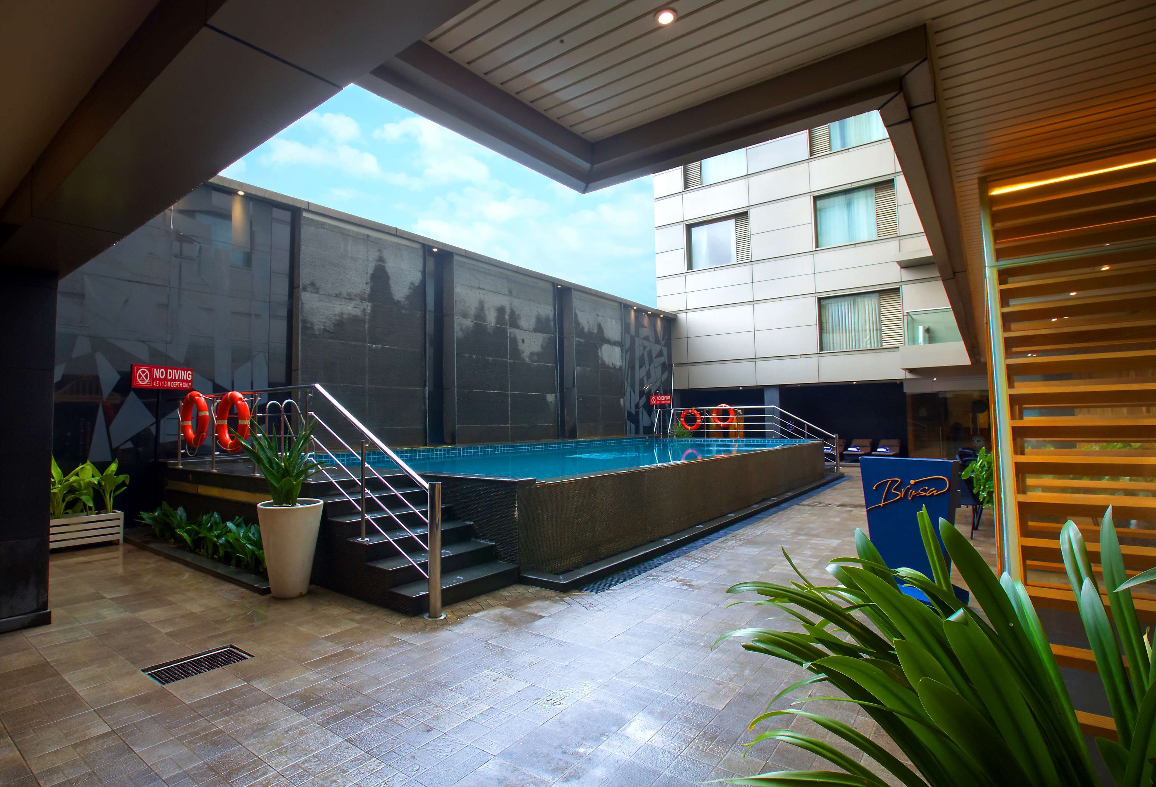 Una piscina interior con pared de vidrio, escaleras que bajan a la piscina y un letrero que indica que no se permite bucear.