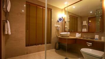 A modern bathroom with a glass shower enclosure, a white sink, and a large mirror.