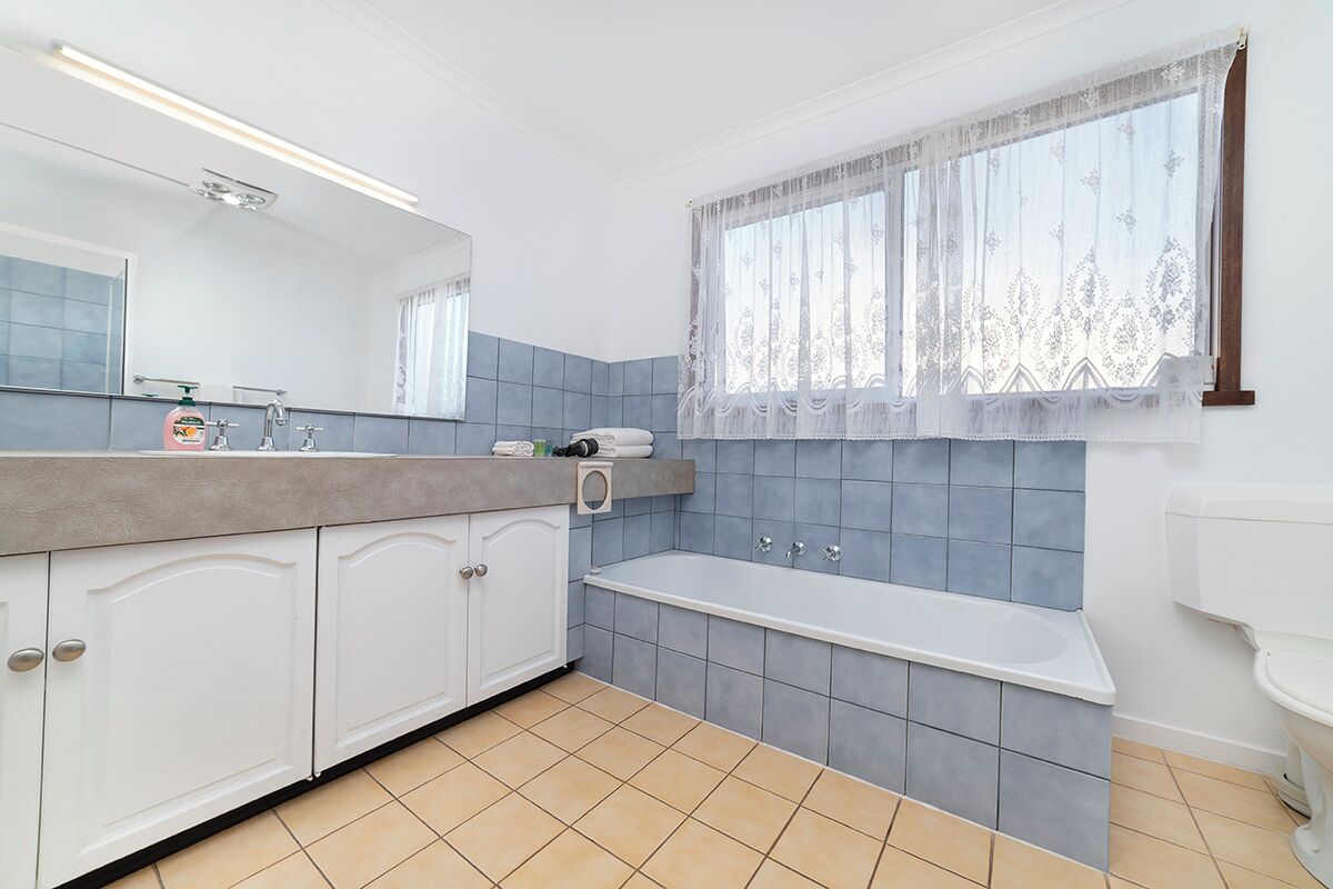 A bathroom with a bathtub, a sink, and a mirror.