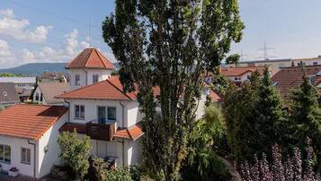 Un quartier résidentiel où les maisons se distinguent par leurs toits recouverts de tuiles rouges et où un arbre imposant se dresse au premier plan.