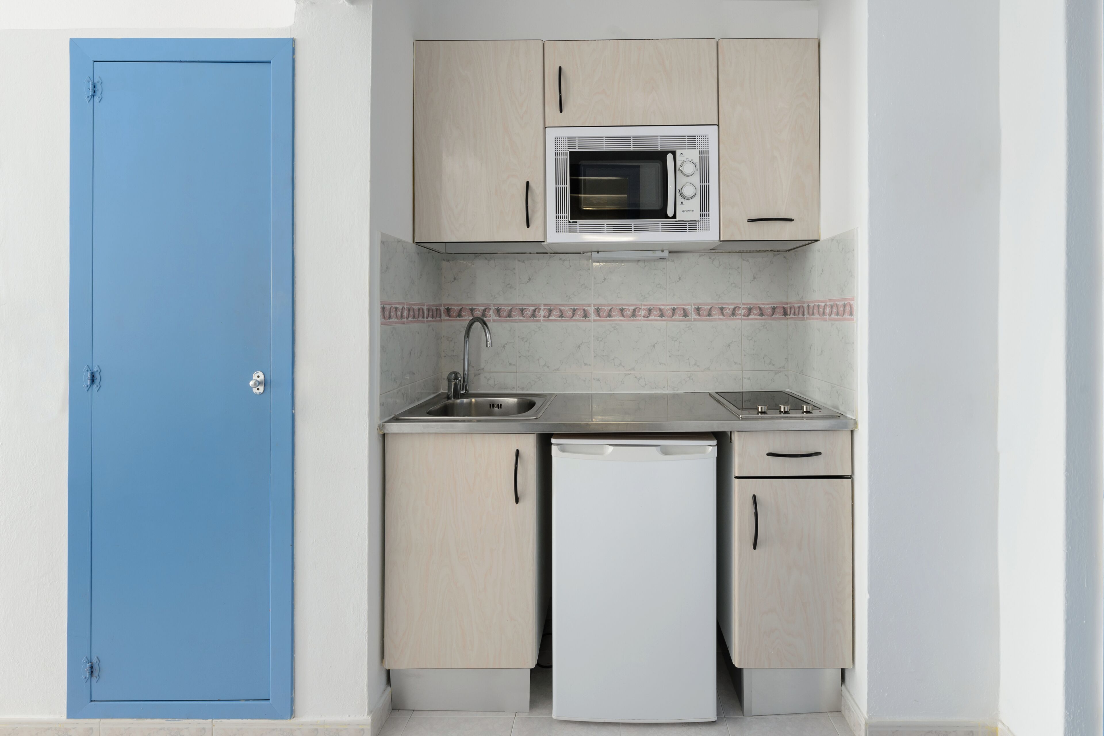 Una cocina compacta equipada con microondas, lavabo y lavavajillas.