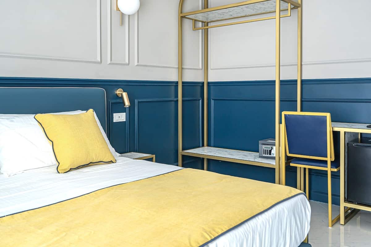 Una habitación de hotel ordenada con cama, escritorio y silla.