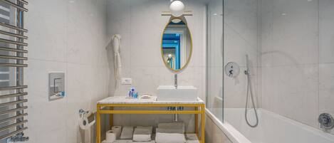 A modern bathroom with a white sink, mirror, and shower.