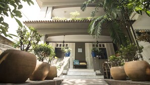 Entrada de um edifício com degraus que levam a uma porta com a inscrição 