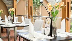 A restaurant setting with tables set for dining, featuring white napkins, menus, and floral centerpieces. - Best Western Trujillo (Trujillo)