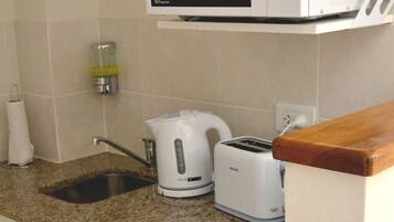 A kitchen with a microwave, toaster, and coffee maker on the countertop.