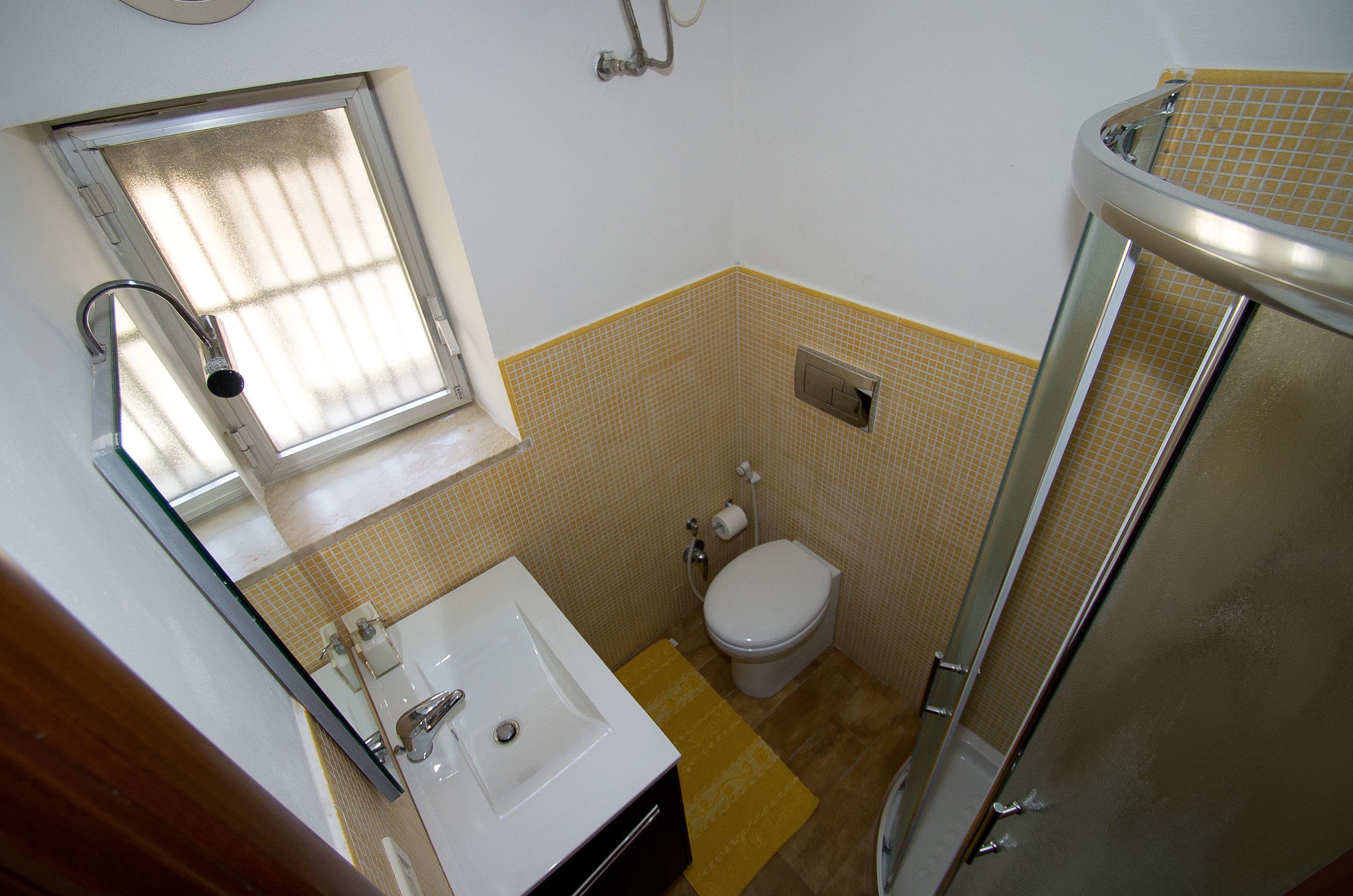 Ein kleines Badezimmer mit Waschbecken, Toilette und Dusche.