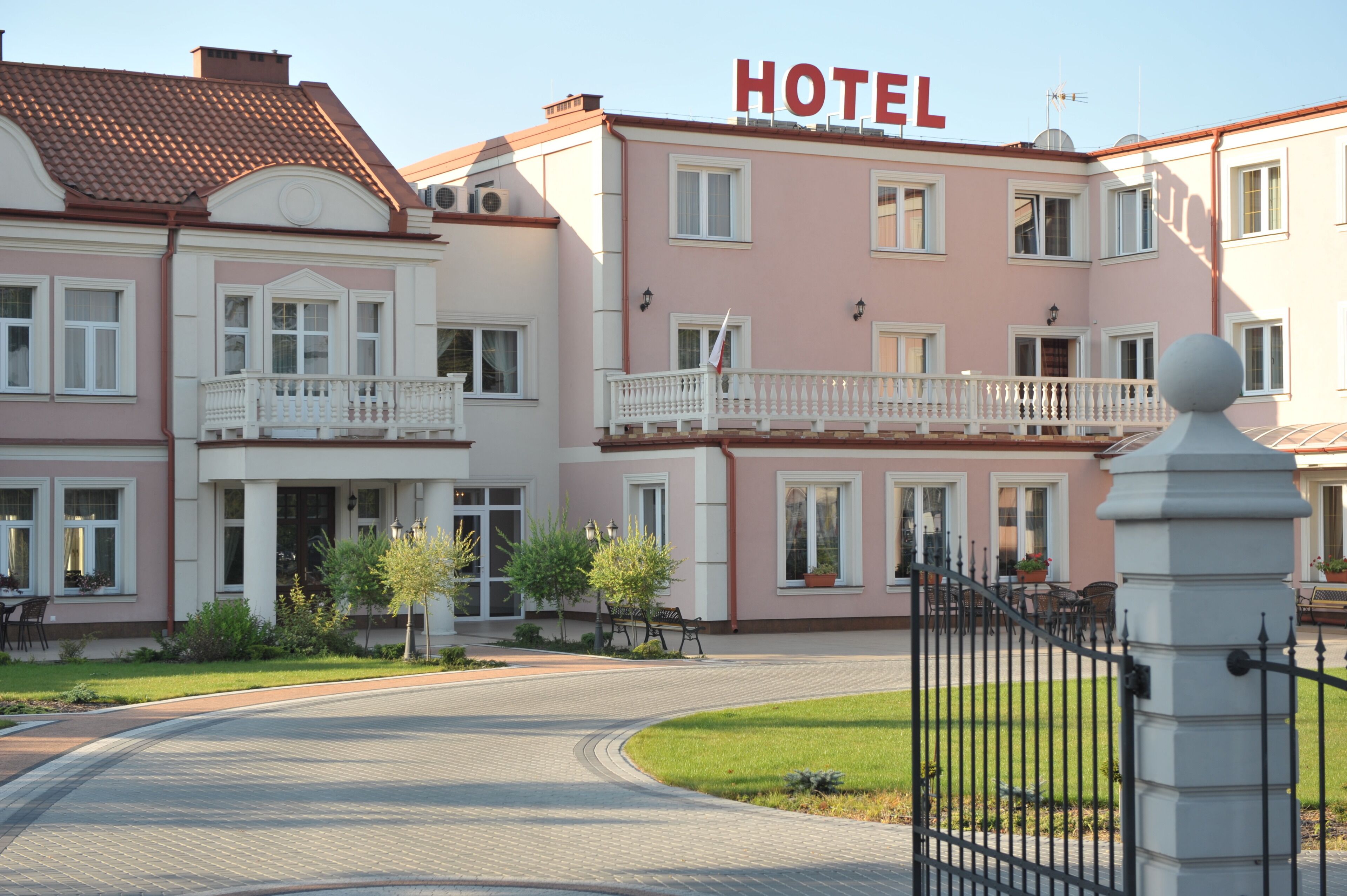 Un hôtel à la façade rose, dot é de nombreux balcons et dont l’entrée est bien visible.