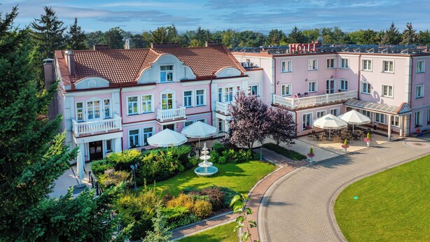 A hotel with a central courtyard, a fountain, and a covered outdoor seating area. - Anin Park Hotel (Warsaw)