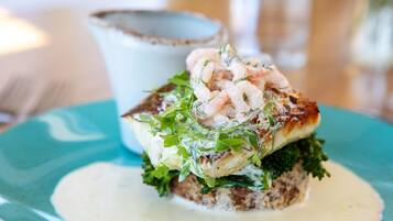 Un plato de mariscos con camarones y vegetales verdes.