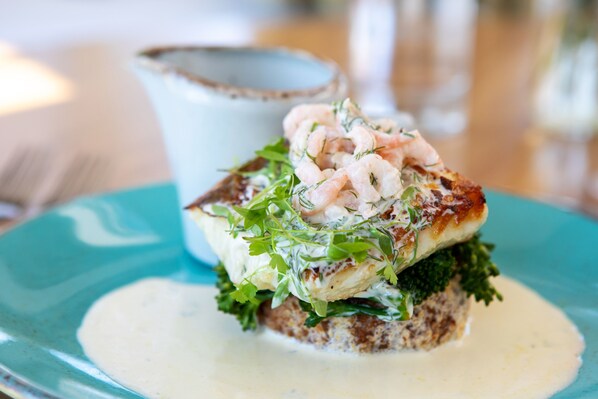 Un plato de mariscos con camarones y vegetales verdes.