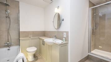 A modern bathroom with a bathtub, a toilet, a sink, and a shower area.