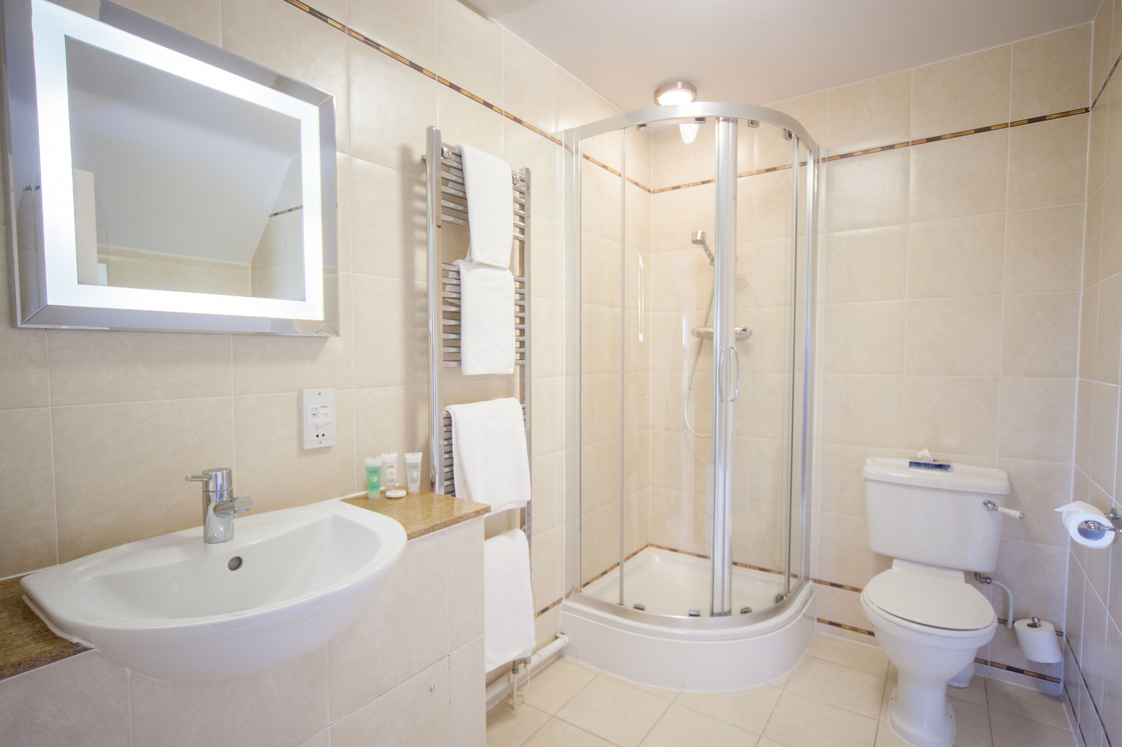 A modern bathroom with a sink, toilet, and glass-enclosed shower.