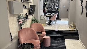 A modern interior with seating, a kitchen area, and a staircase. - Hotel Agenor (Paris)