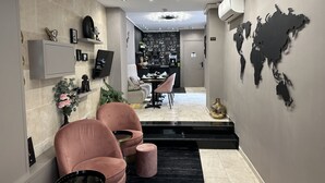 A modern interior with a seating area, a coffee bar, and a world map on the wall. - Hotel Agenor (Paris)