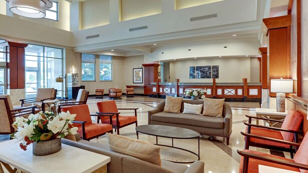 A spacious lobby with a seating area, a reception desk, and a kitchen in the background.