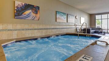 An indoor swimming pool with a 3 FT depth marker, tiled walls, and artwork.