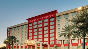A Drury Inn & Suites hotel with a red facade, multiple floors, and a covered entrance.