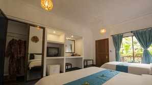 A hotel room with two beds, a TV, a desk, and a wardrobe.