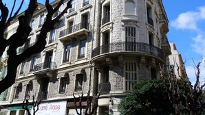 Un edificio storico in pietra con numerosi balconi e un cartello con su scritto "Carré Rose Feminine".