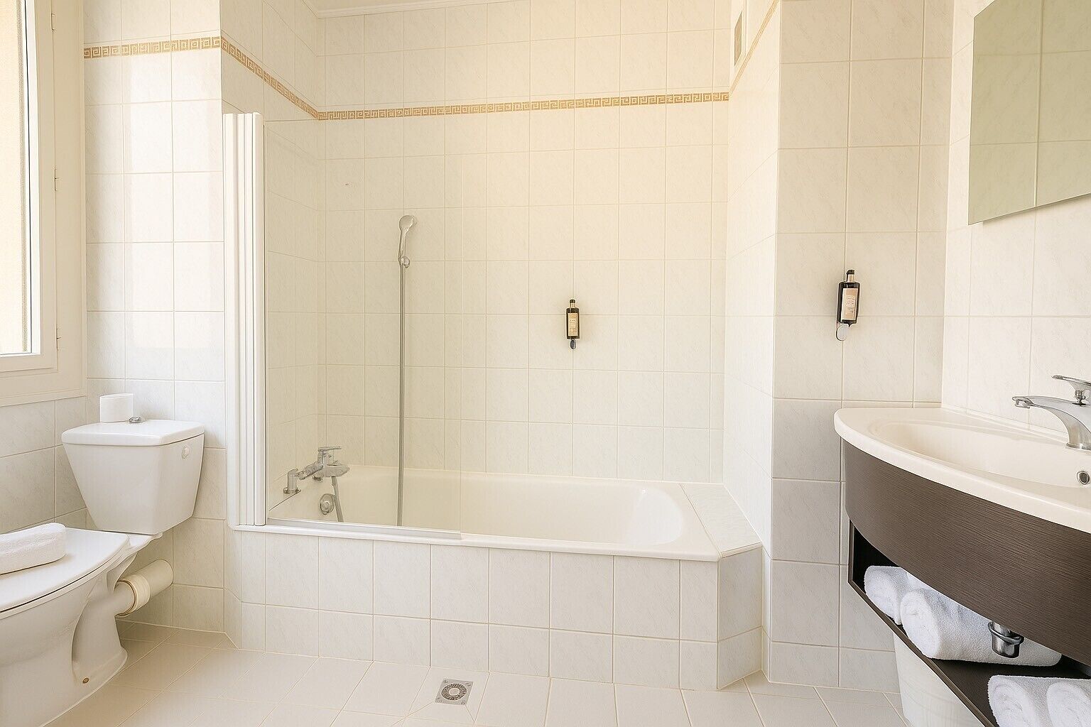 A bathroom with a toilet, a bathtub, and a sink.