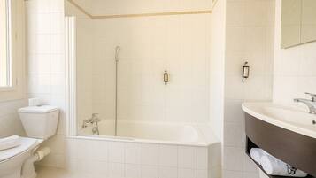 A bathroom with a toilet, a bathtub, and a sink.