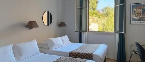 Una habitación de hotel con dos camas, una ventana y vistas, y una silla.
