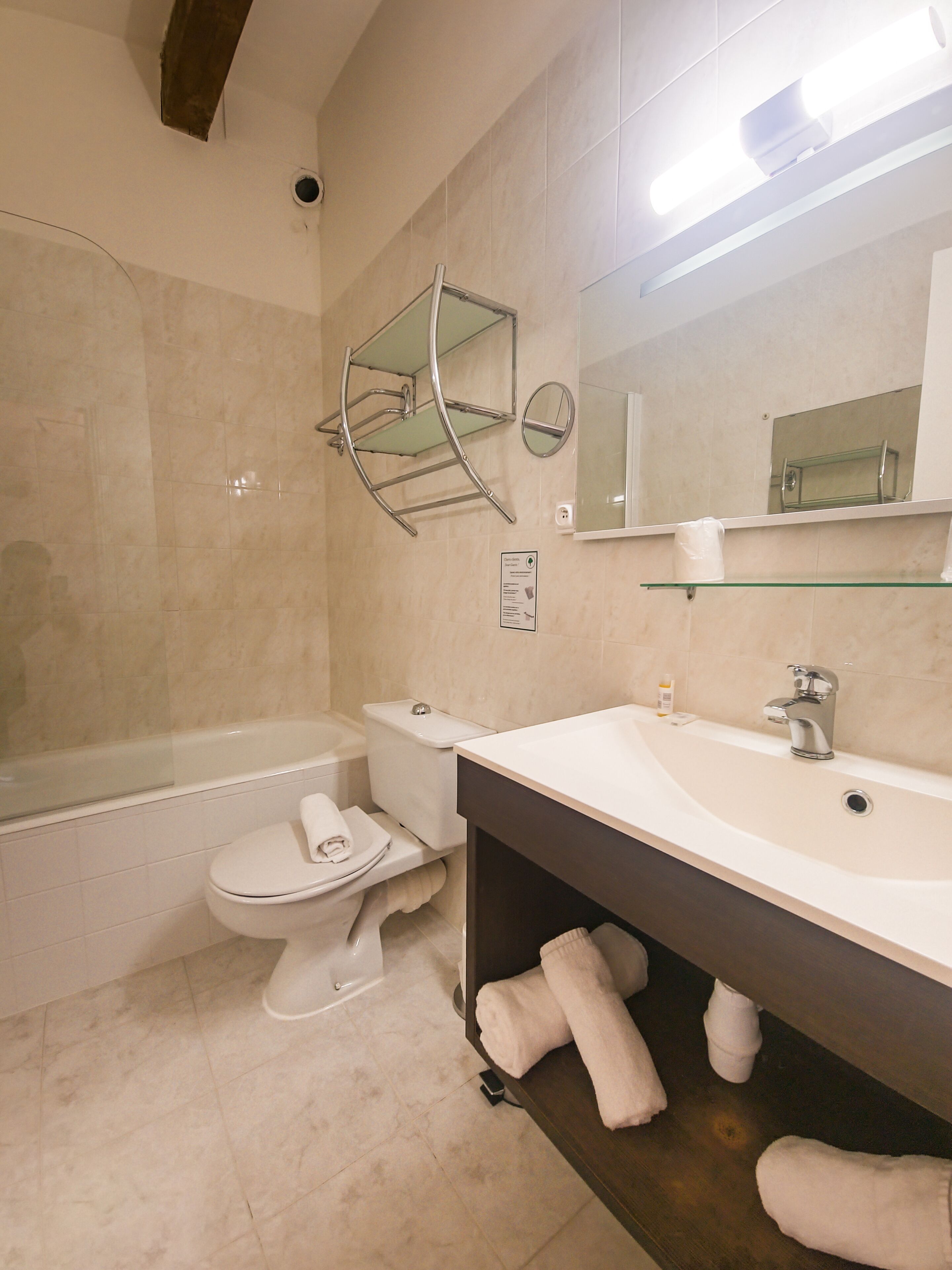 A modern bathroom with a bathtub, toilet, and vanity.