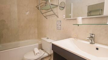 Un baño moderno con bañera, inodoro y tocador.