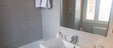 A modern bathroom with a bathtub, a sink, and a mirror.