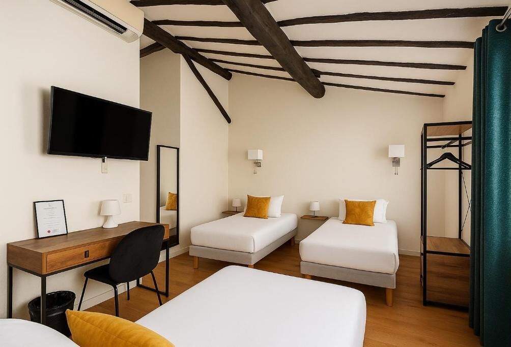 Habitación triple Confort | Colchones con acolchado adicional y tabla de planchar con plancha