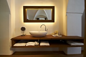 A bathroom with a large mirror, a vessel sink, and a wooden vanity.