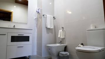 Une salle de bain moderne avec un lavabo, un meuble-lavabo et des toilettes, le tout de couleur blanche.