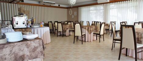 A dining area with tables set for service, a coffee machine, and a buffet station.