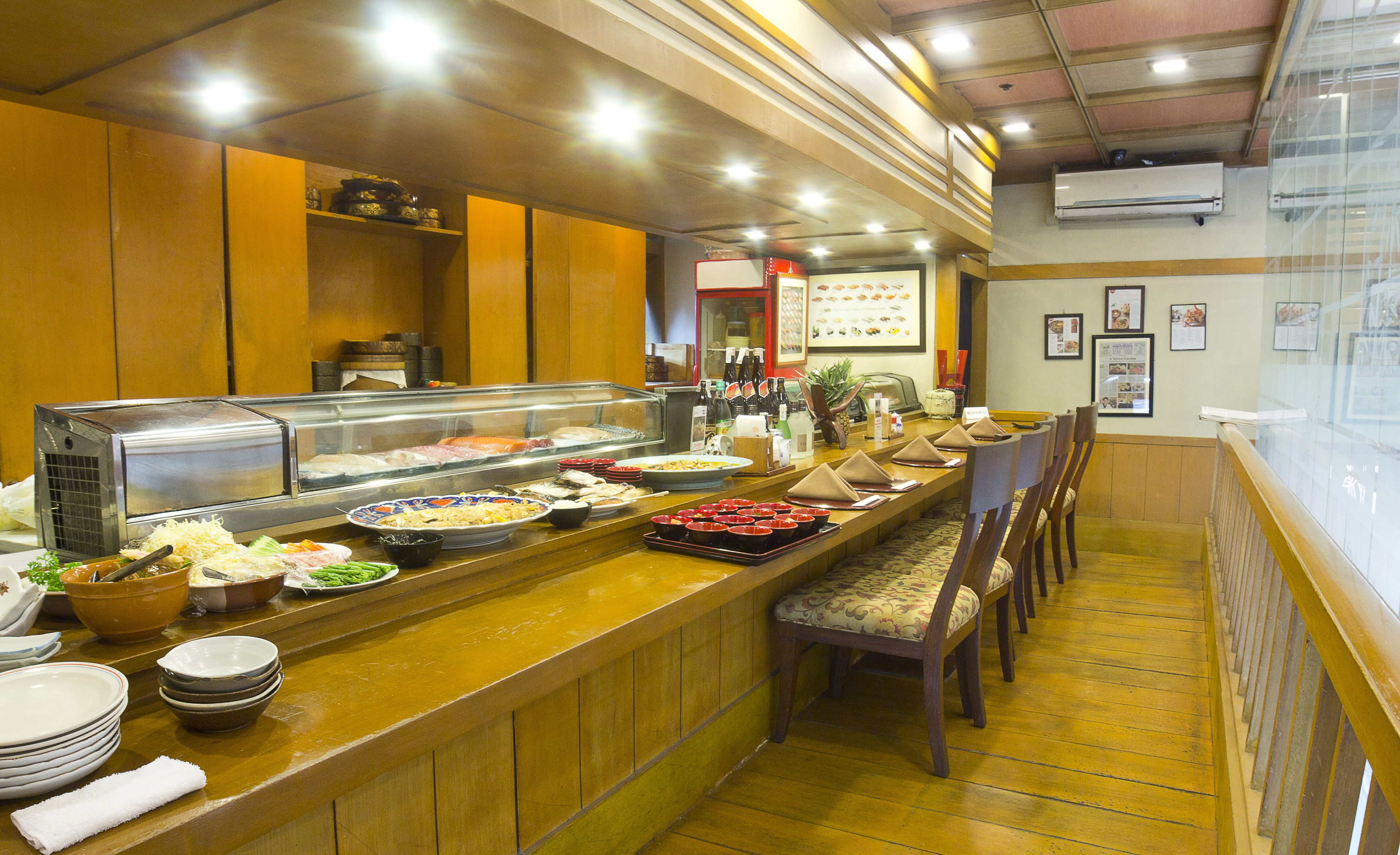 A buffet setup with various food items and a seating area with chairs.