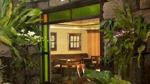 A room with wooden chairs and a stone wall. - Herald Suites (Makati)