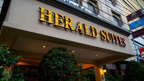 The exterior of the Herald Suites hotel with a prominent sign. - Herald Suites (Makati)