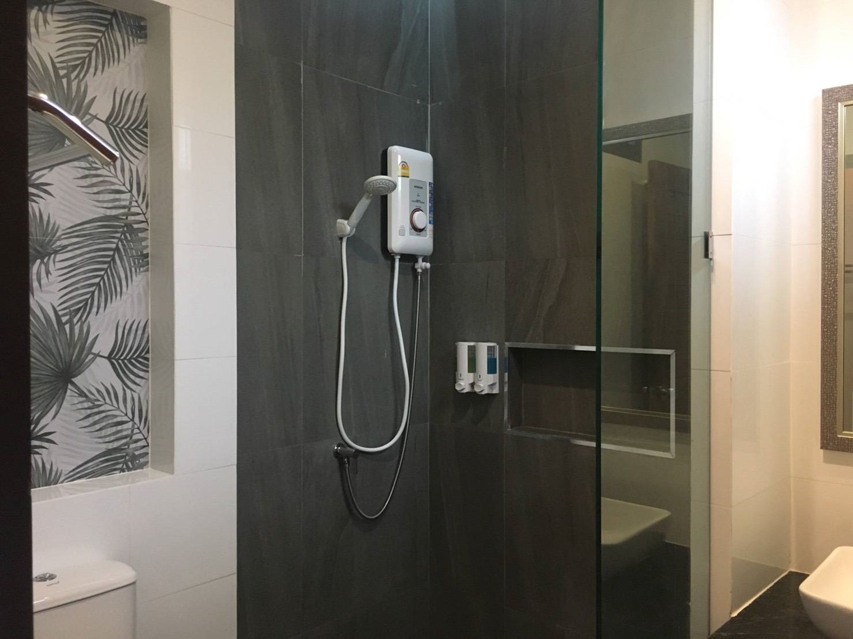 Un baño moderno con cabina de ducha de vidrio, inodoro y lavabo.