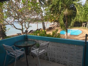 A terrace with a pool, chairs, and a view of the beach and sea. - Blu' Beach Bungalows (Koh Samui)