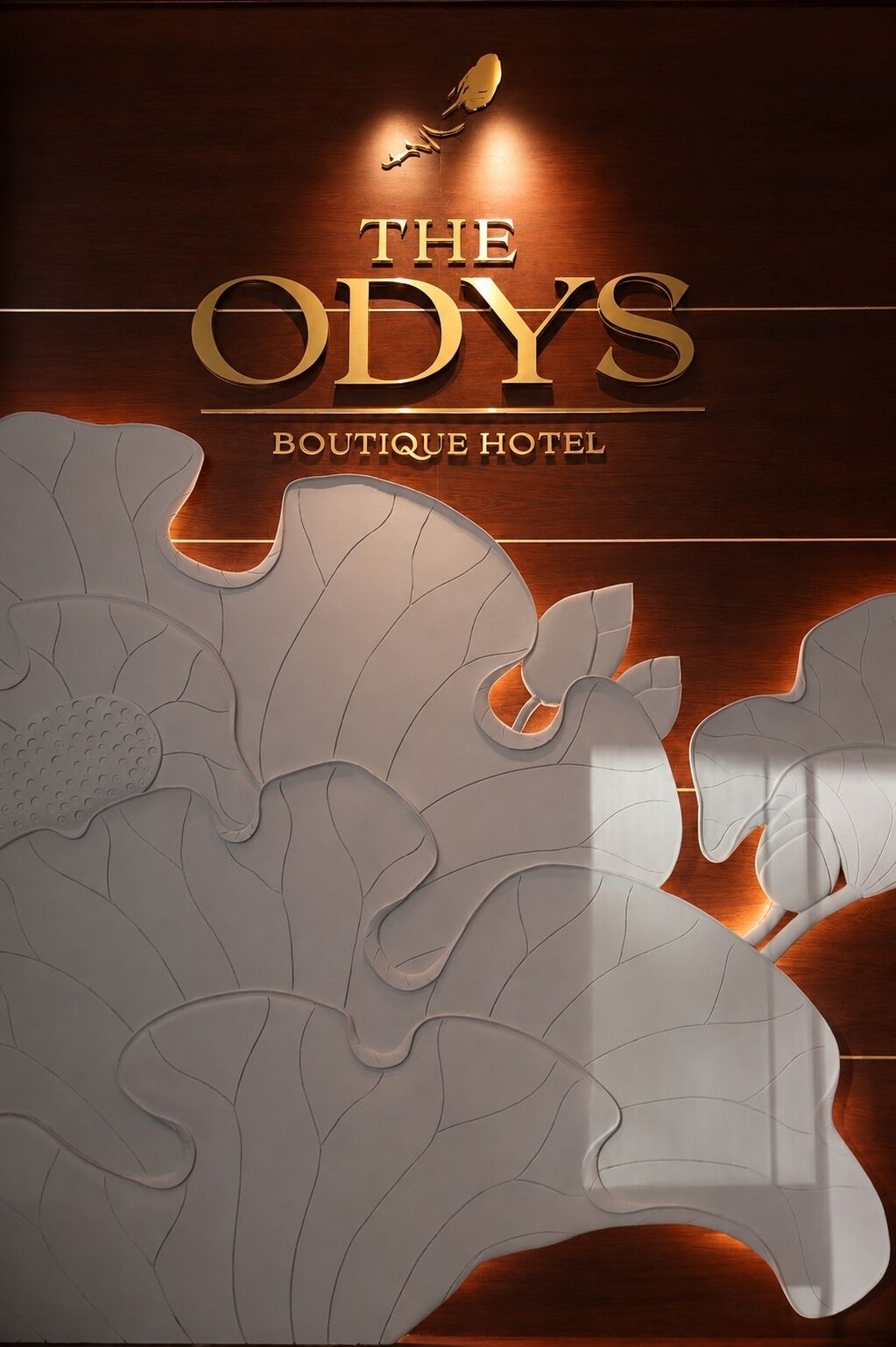 Ein Hotelschild mit dem Namen 'The Odyssey Boutique Hotel' und einem stilisierten Vogel-Logo.
